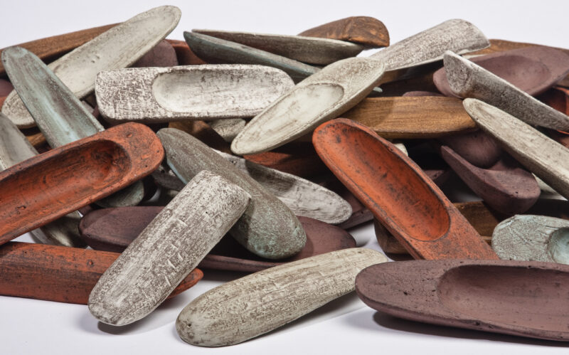 IMG_5988 - direktorenhaus A pile of variously colored clay shoe forms, featuring textures in shades of brown, white, and green.
